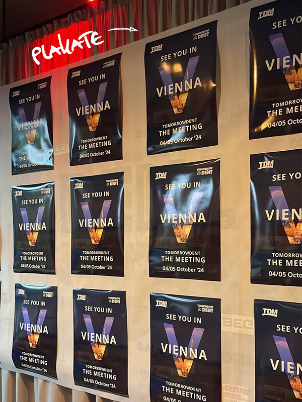 plakate mit tdm logos und infos haengen an einer wand